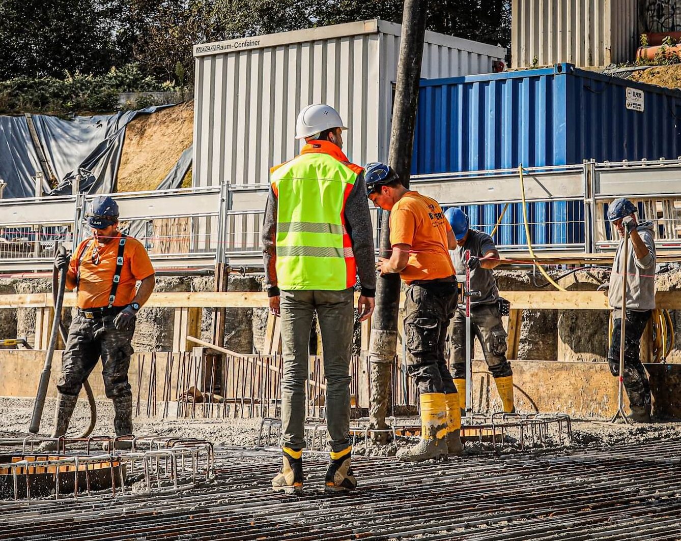 Bauarbeiter gießen Beton und bereiten die Grundfläche auf einer Baustelle vor.