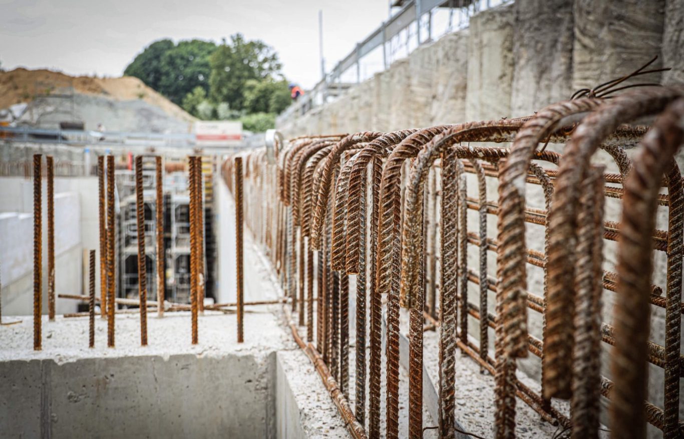 Bauarbeiten mit Stahlbewehrung und Betonelementen in einer Baustelle.