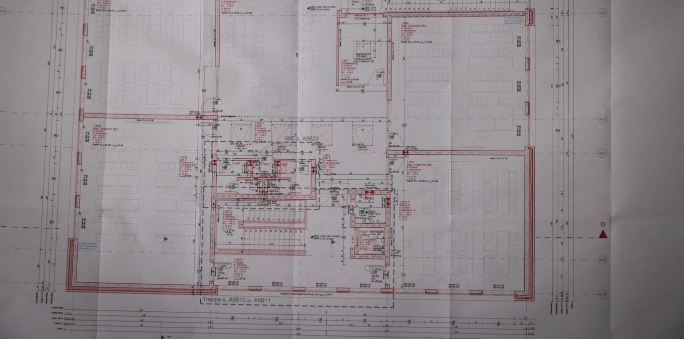 Bauplan mit verschiedenen Räumen und Dimensionen in Rot und Schwarz.