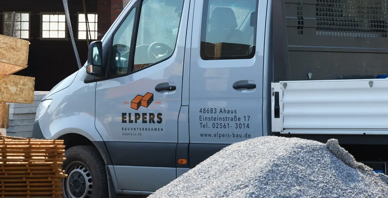 Holztafel mit dem Schriftzug "ELPERS" auf einer Baustelle.